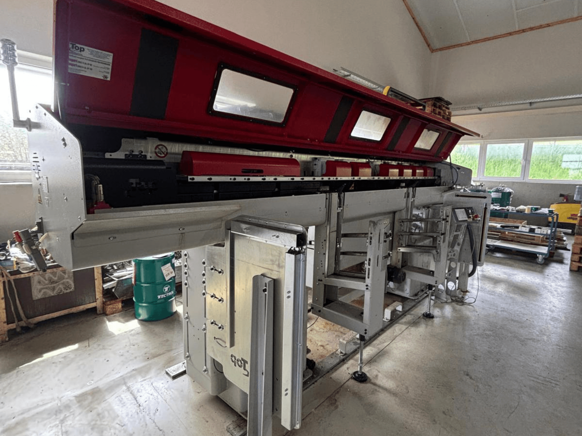 TOP Automazioni – model Top Loader ETL 10-75 widziany z boku, z czerwoną górną częścią i skomplikowanymi elementami mechanicznymi.
