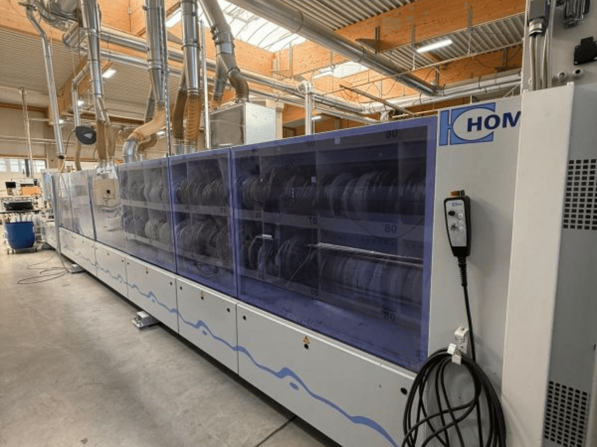 Pralka przemysłowa HOM, widok z przodu, z przezroczystym panelem wyświetlającym naczynia; panel sterowania z przyciskami z boku.