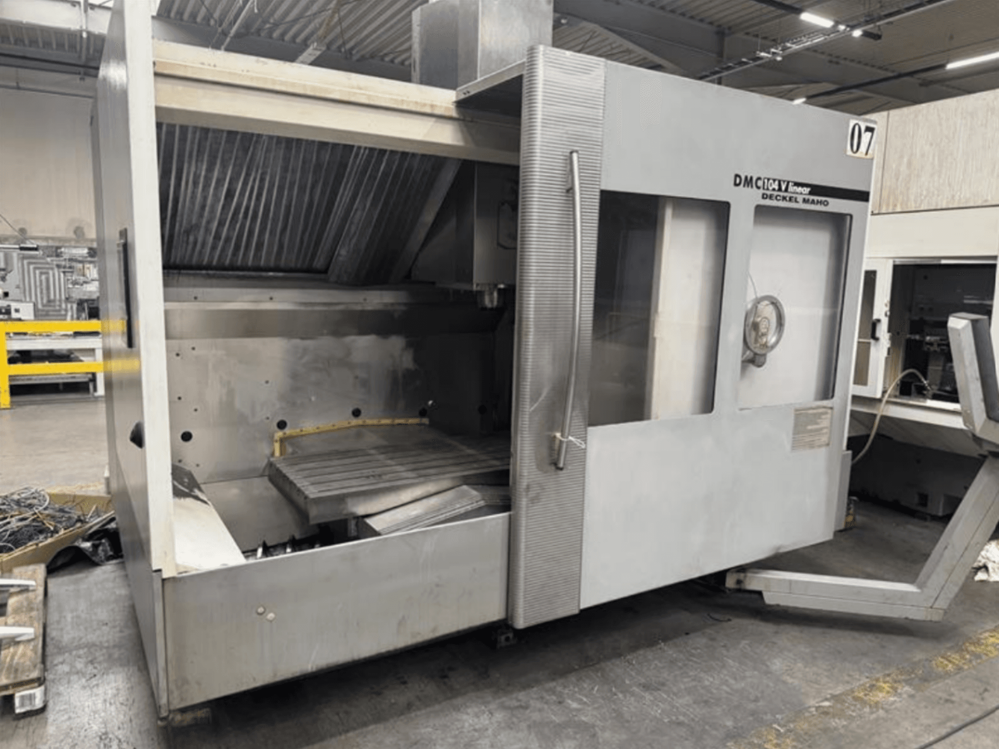 Maszyna liniowa DMC 104 V firmy Deckel Maho, widok z przodu, z pustym obszarem obróbki i dużym stołem roboczym.