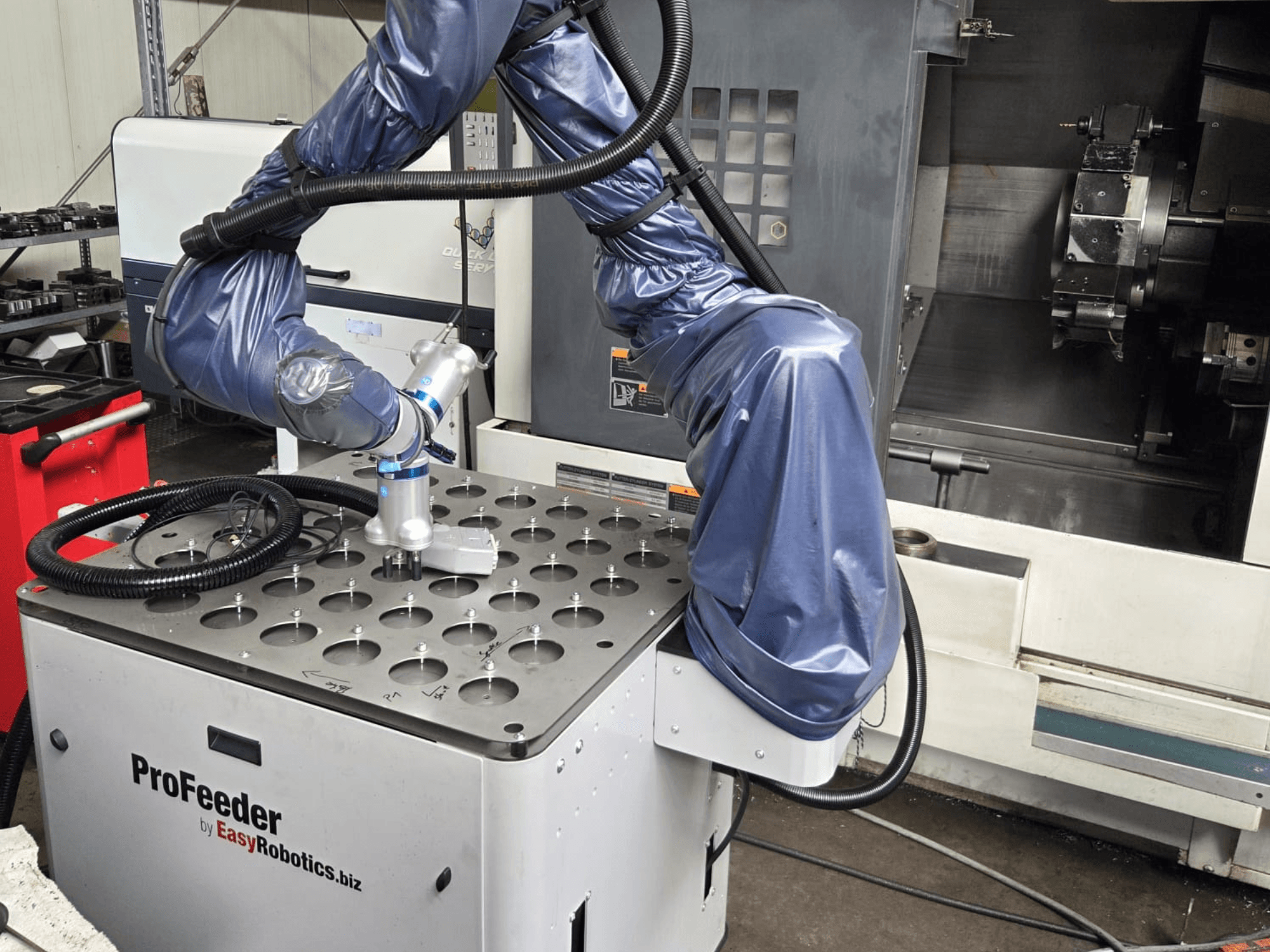 Robot współpracujący EASYROBOTICS ProFeeder w widoku z przodu, z ramieniem robota umieszczonym nad perforowanym metalowym stołem.