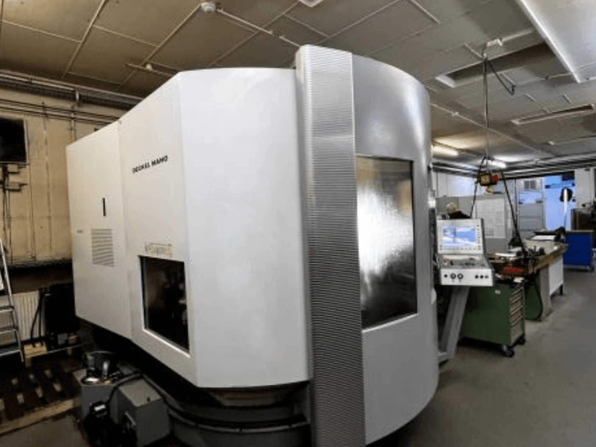 Maszyna CNC SODICK MAKO w warsztacie, widok z boku, z panelem sterowania i obszarem roboczym widocznym w tle.