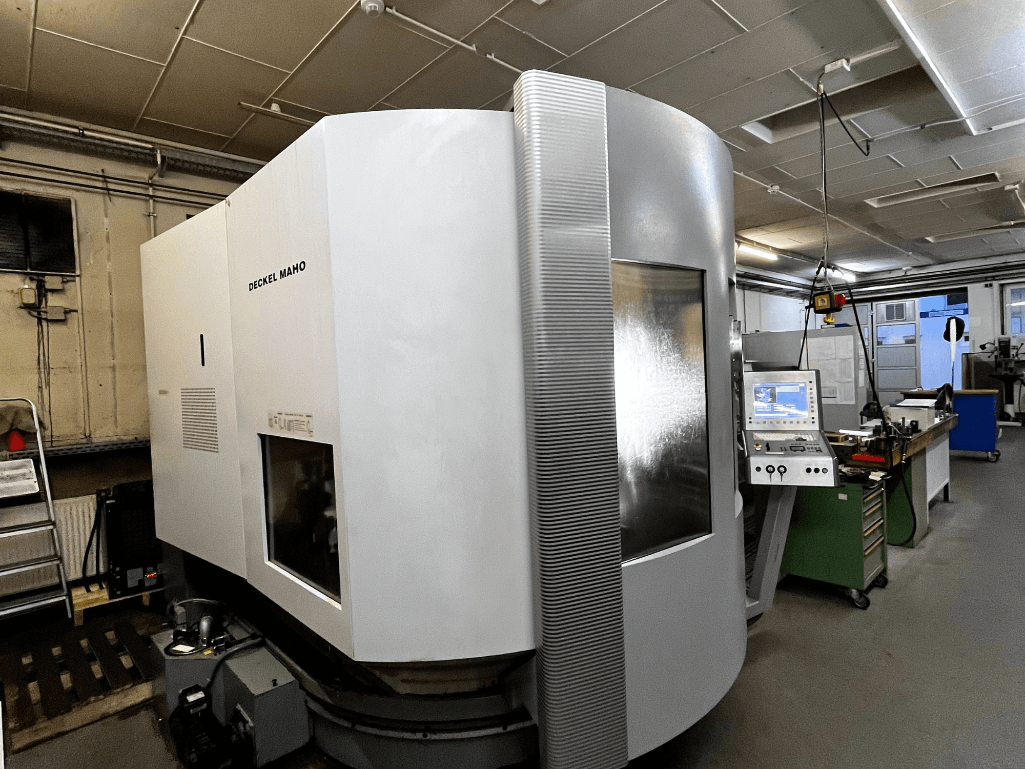 Maszyna CNC Deckel Maho, widok z przodu, biała obudowa, widoczny panel sterowania, ustawienie warsztatowe.
