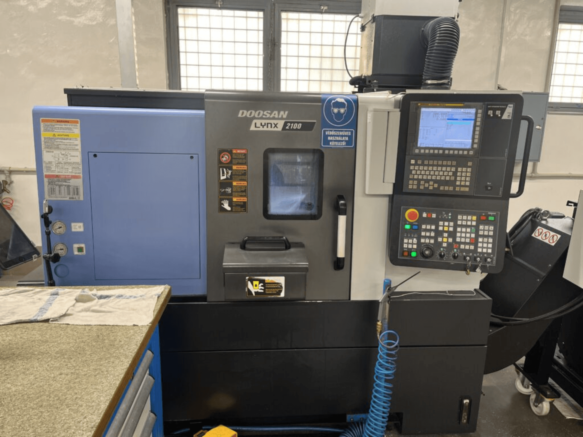 Tokarka pozioma DOOSAN Lynx 2100A, widok z przodu z panelem sterowania, interfejsem operatora i funkcjami maszyny.