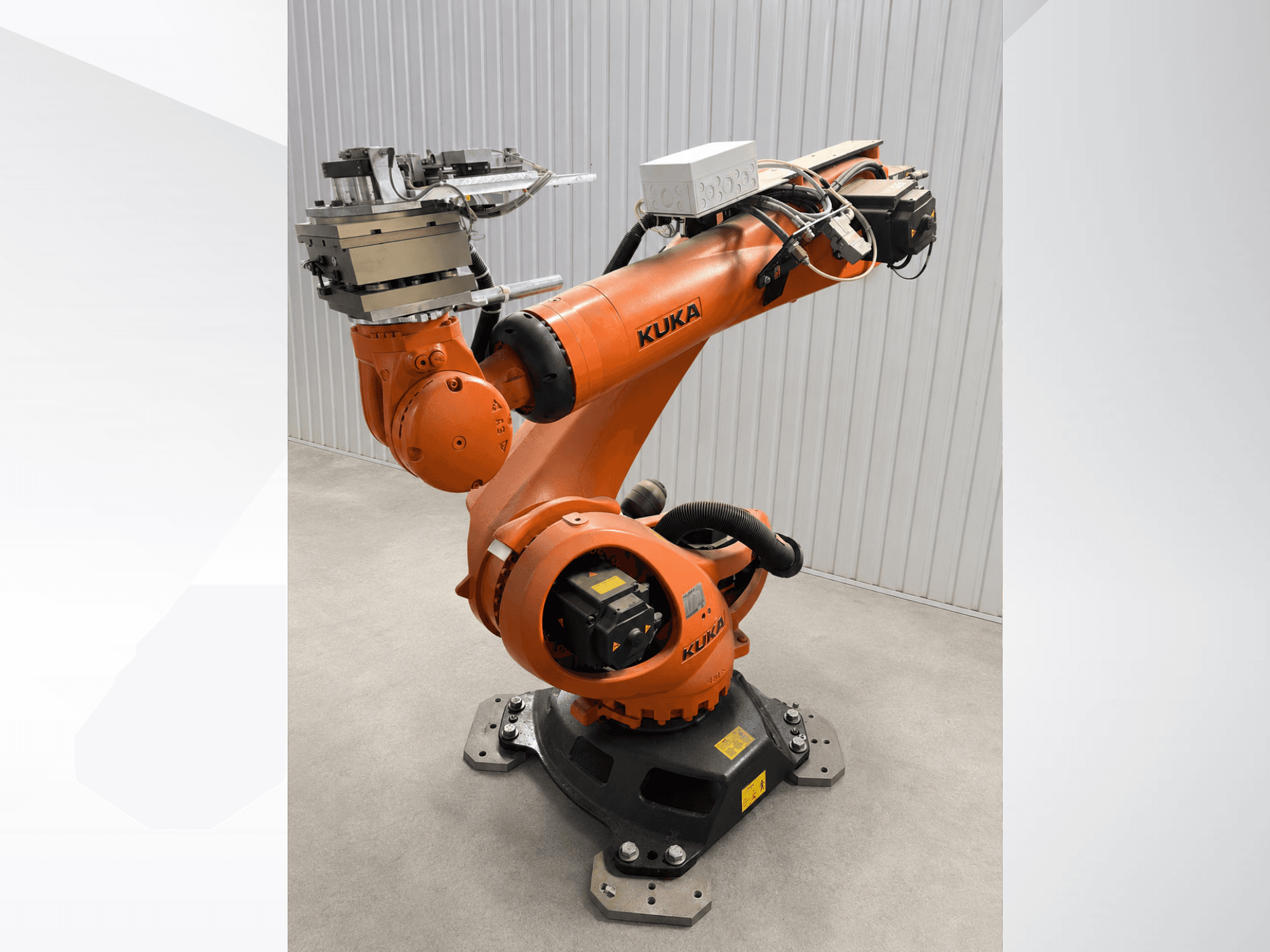 Dodatkowe ramię robota KUKA KR 90 R3100 w kolorze pomarańczowym, widok z boku, przedstawiające przeguby, sterownik oraz mocowanie narzędzia na efektorze końcowym.