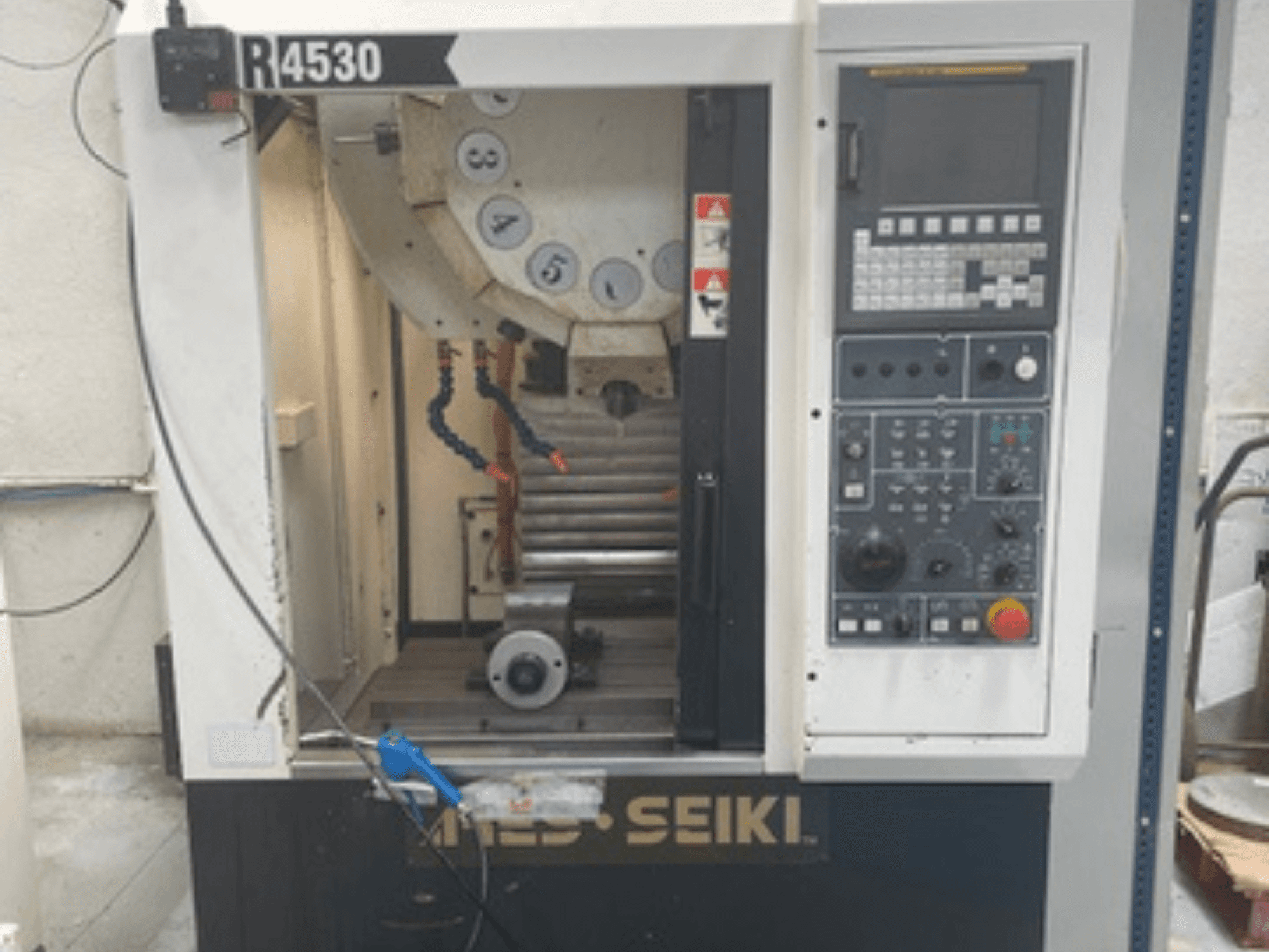 Pionowe centrum obróbcze ARES-SEIKI R4530, widok z przodu przedstawiający panel sterowania i obszar roboczy z wrzecionem i układem chłodzenia.