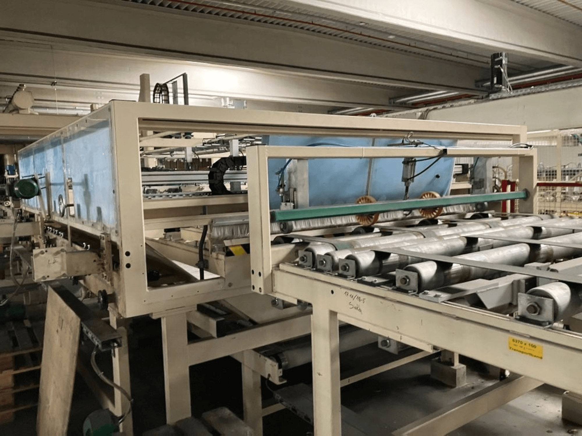 Prasa do laminowania WEMHÖNER KT-F-1E, widok z boku, wyposażona w rolki i elementy sterujące do przetwarzania materiałów w warunkach fabrycznych.