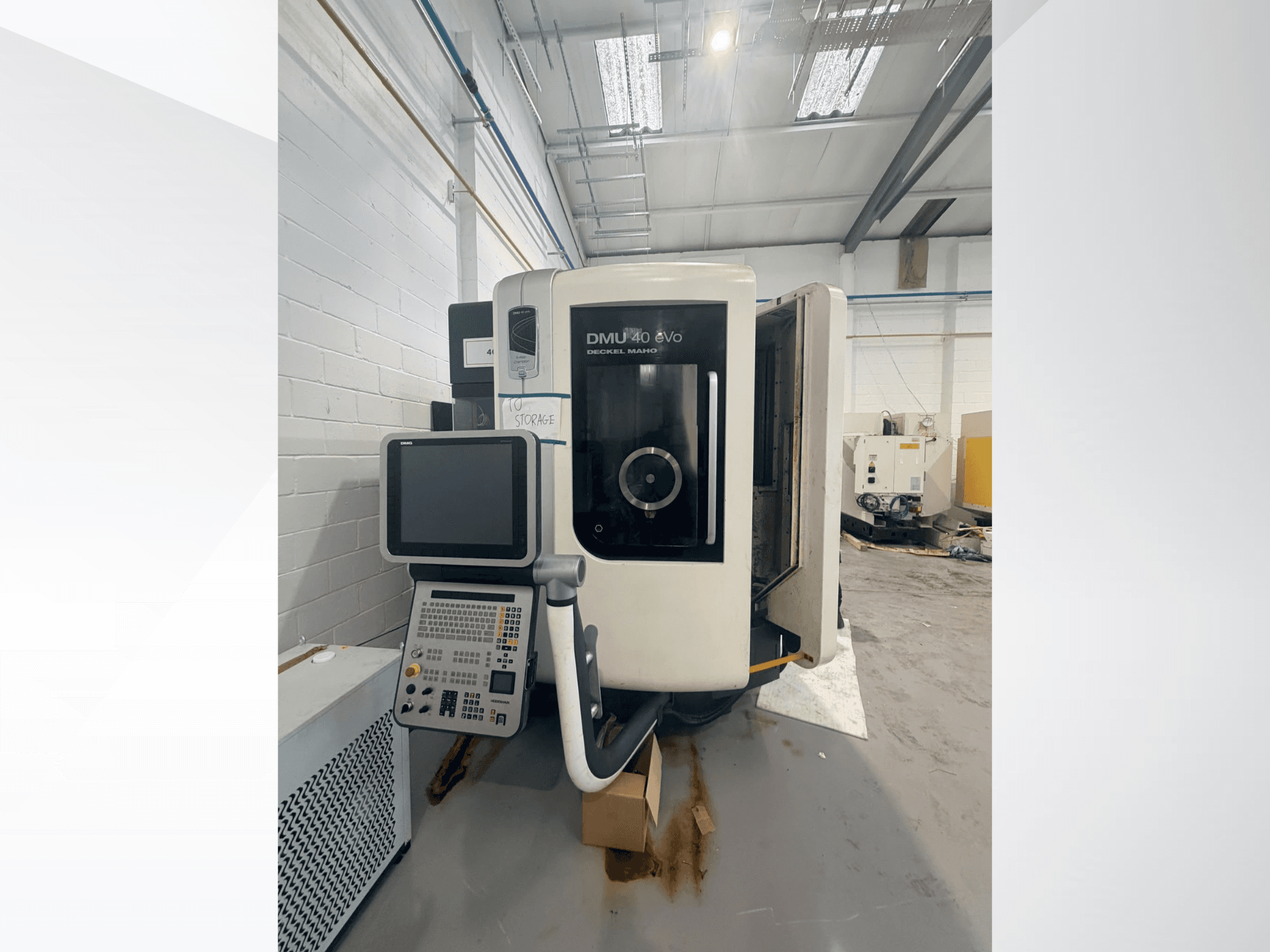 Centrum obróbcze pionowe DMG DMU 40 evo – widok z przodu, przedstawiający panel sterowania i obszar wrzeciona, z przestrzenią roboczą w tle.