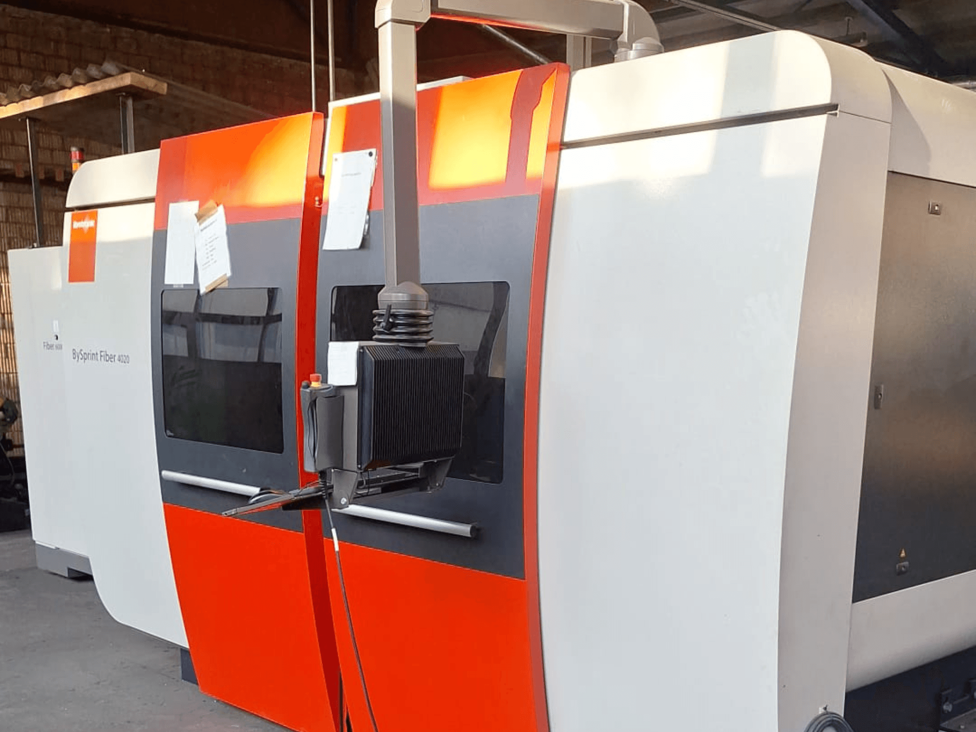 Wycinarka laserowa BySprint Fiber 4020, widok z boku, czerwono-biała obudowa, widoczny szczegółowy panel sterowania.