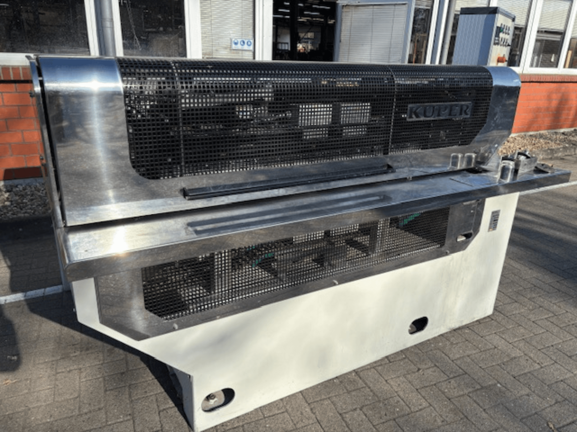 Gilotyna do forniru KUPER FLI, widok z przodu, z korpusem ze stali nierdzewnej i siatką ochronną zapewniającą bezpieczną pracę.