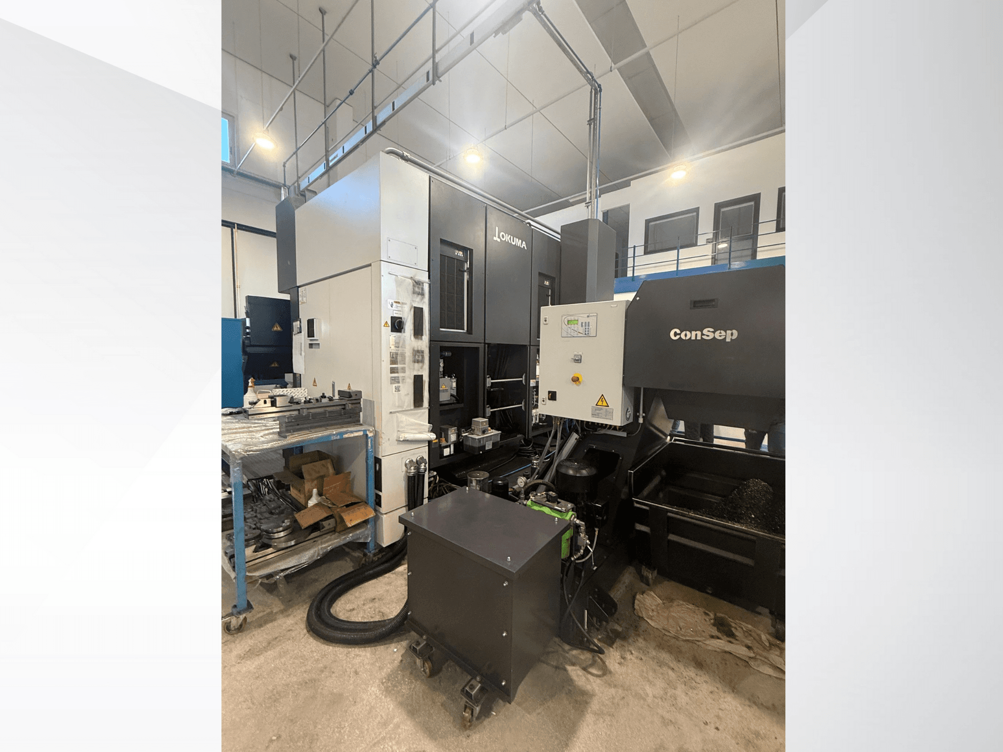 Centrum obróbcze Okuma z jednostką ConSep, widok z boku, wyświetlanie elementów sterujących i konfiguracji przemysłowej, w tym pojemnik na wióry metalowe.