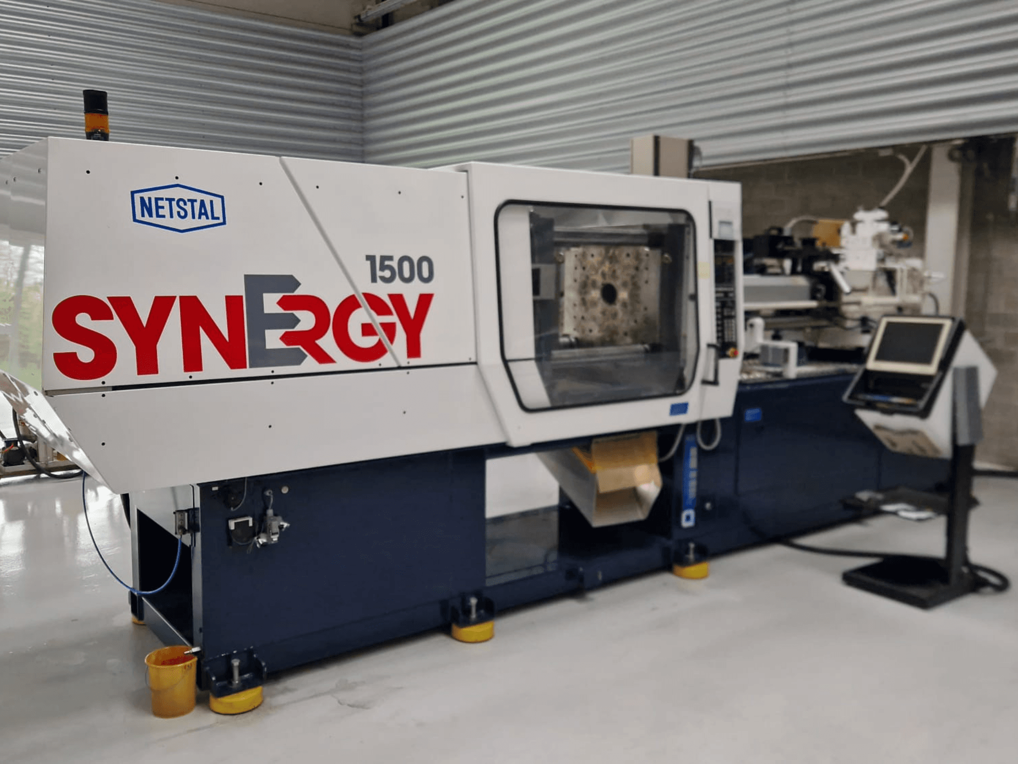 Wtryskarka hydrauliczna Netstal Synergy 1500-460, widok z przodu, panel sterowania i otwarty obszar wtrysku.