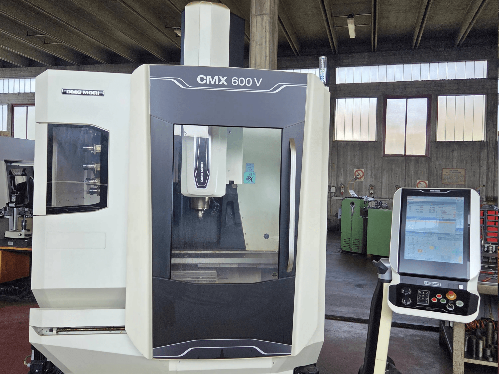 Pionowe centrum obróbcze DMG MORI CMX 600V widziane z przodu, z widocznym panelem sterowania i szczegółowym ujęciem obszaru wrzeciona.