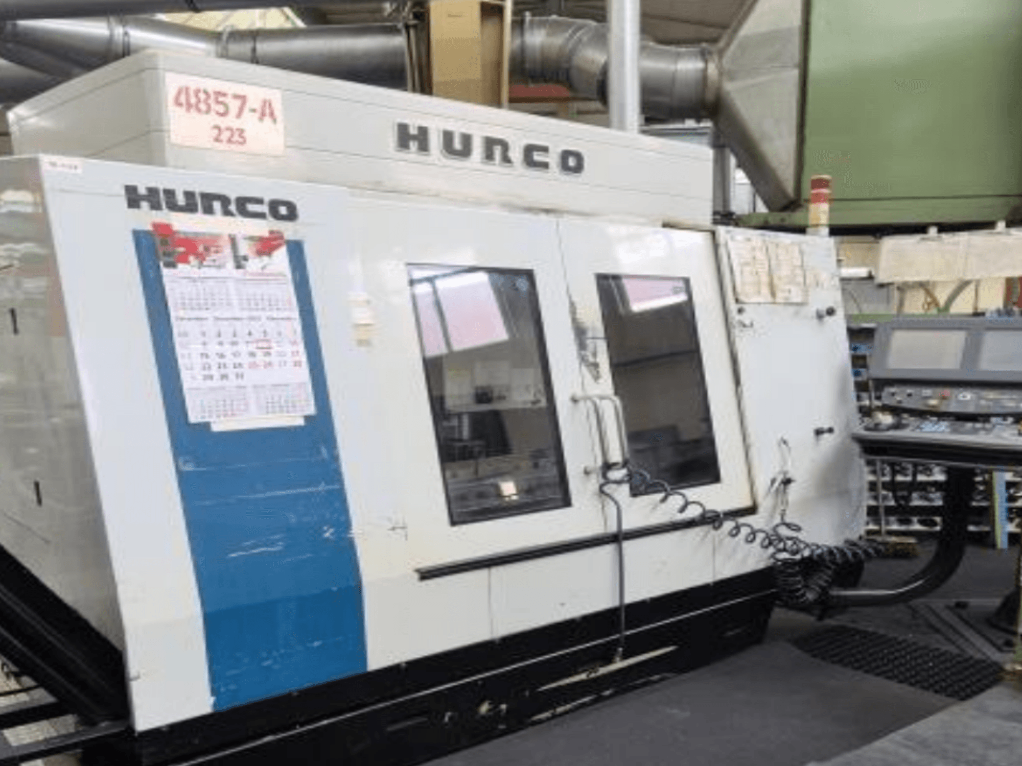 Pionowe centrum obróbcze Hurco VMX 42 w widoku z przodu, z panelem sterowania, kalendarzem i metalowymi detalami zewnętrznymi.