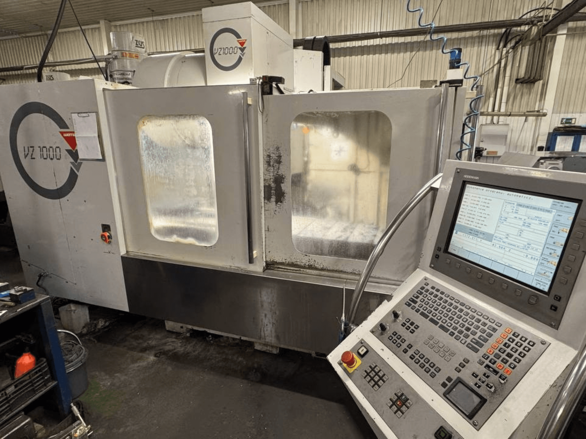 Widok z przodu pionowego centrum obróbczego WEMAS VZ 1000 z panelem sterowania i przezroczystymi drzwiami dostępu.