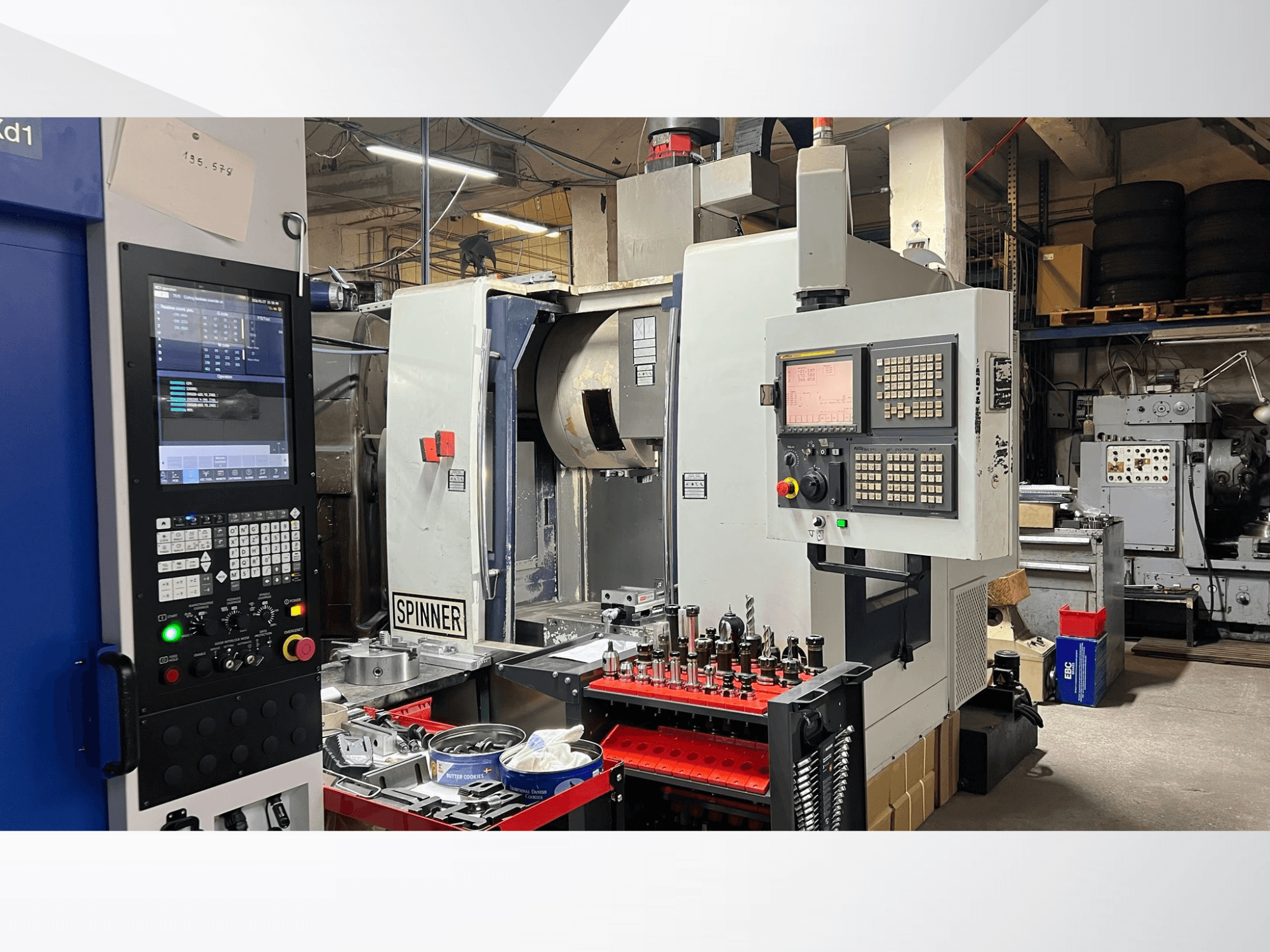 Maszyna CNC z widocznym panelem sterowania, narzędziami i obrabianymi przedmiotami, widziana z przodu w środowisku warsztatowym.