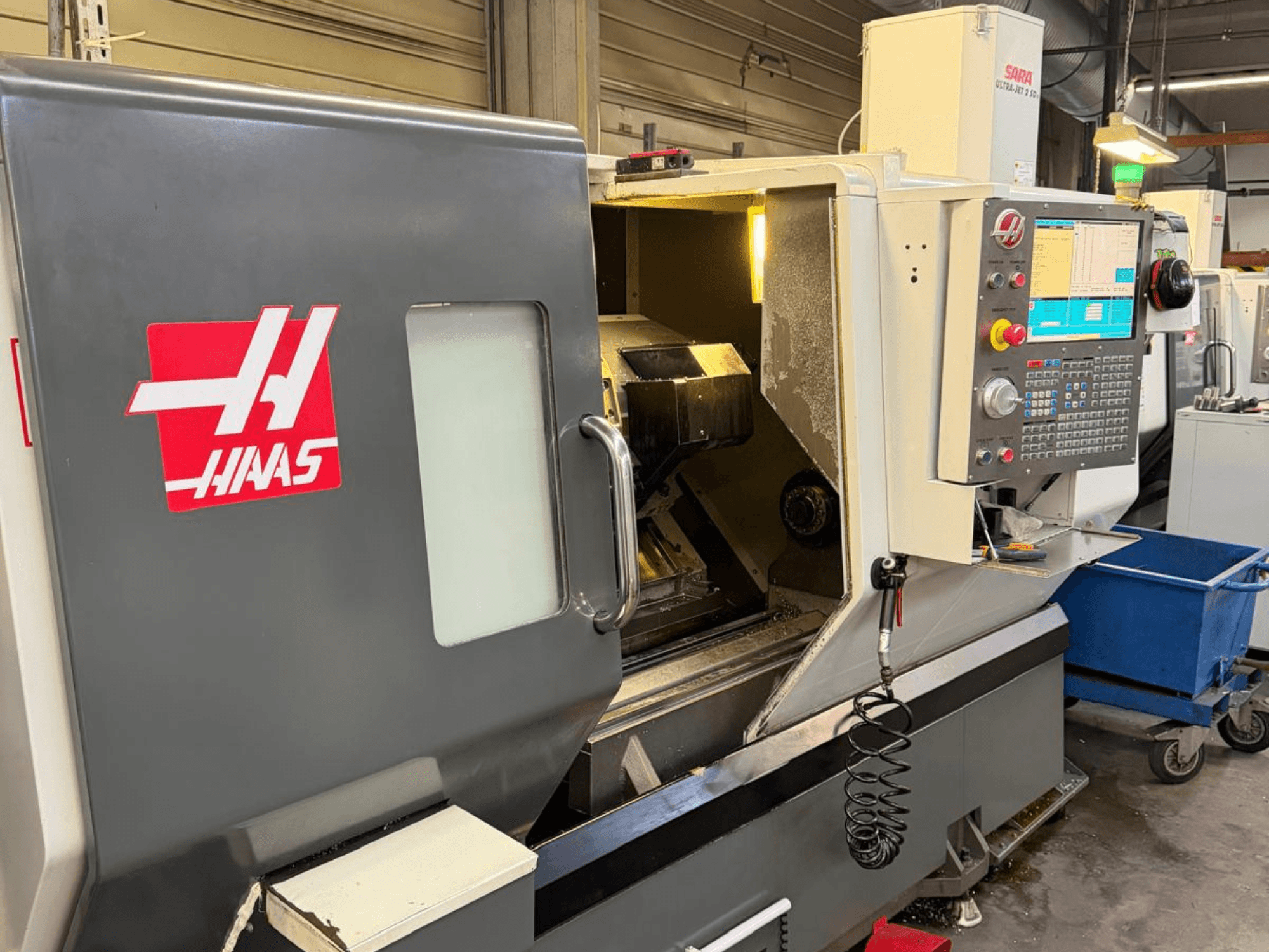 HAAS DS-30SSY tokarka pozioma, widok z przodu, z widocznym panelem sterowania i elementami wewnętrznymi, w warunkach warsztatowych.