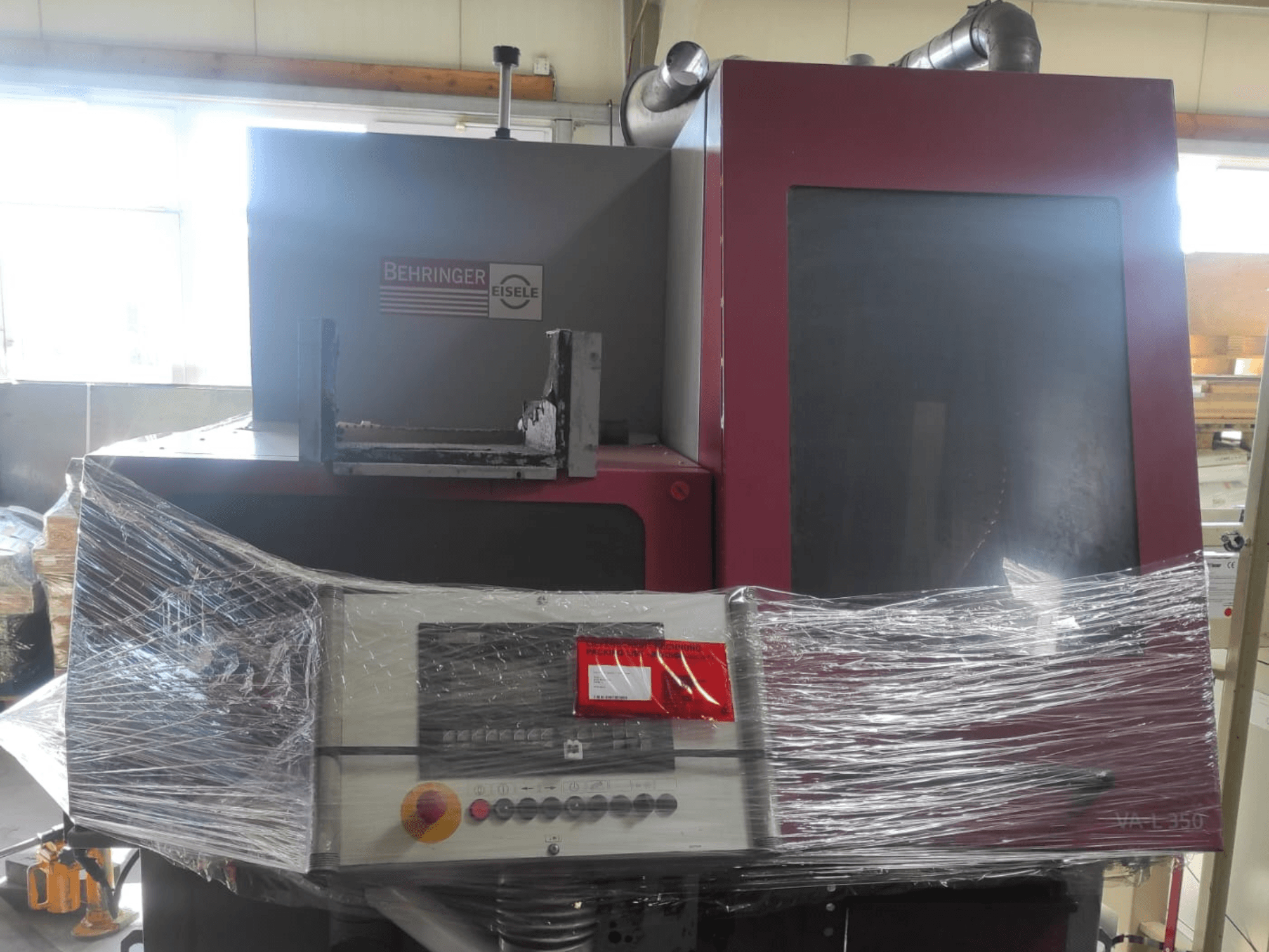 Maszyna Behringer Eisele VA L 560, widok z przodu, owinięta plastikiem, z widocznym panelem sterowania i przyciskami.