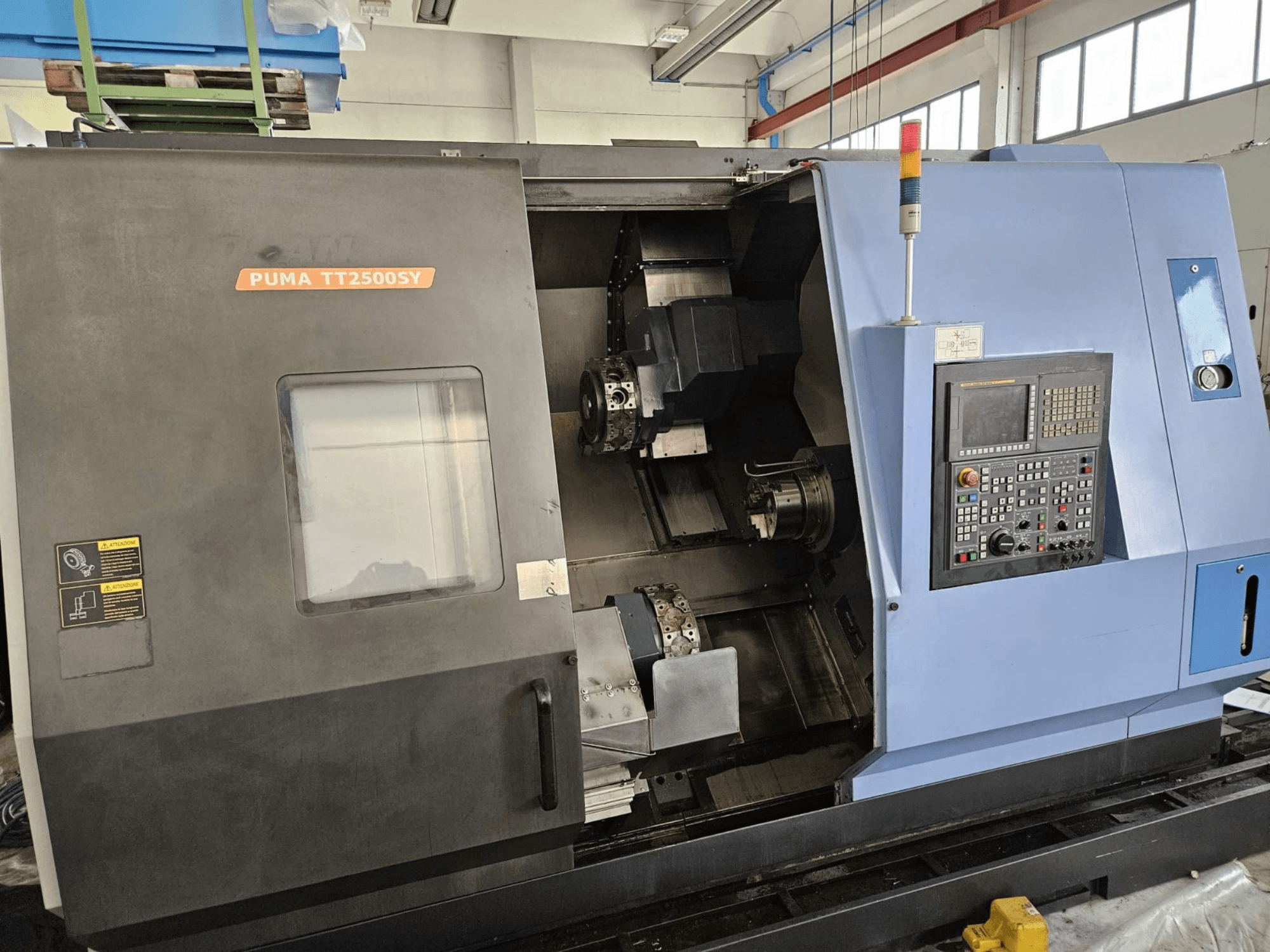 Wielowrzecionowa tokarka DOOSAN PUMA TT2500SY – widok z przodu przedstawiający panel sterowania oraz szczegóły wnętrza maszyny.