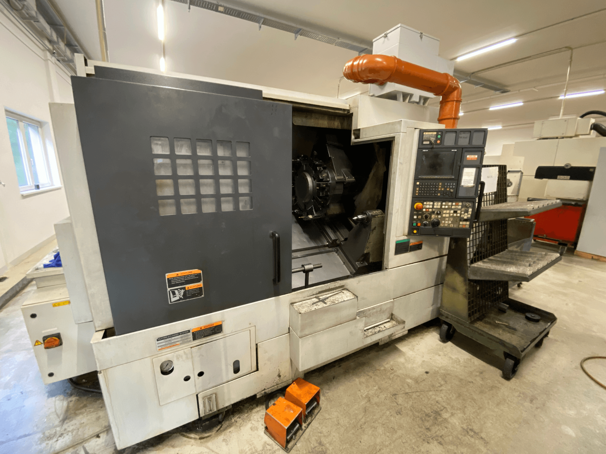 Centrum tokarsko-frezarskie DMG Mori Seiki NL2500Y/700 – widok z przodu przedstawiający panel sterowania oraz szczegóły obudowy maszyny.