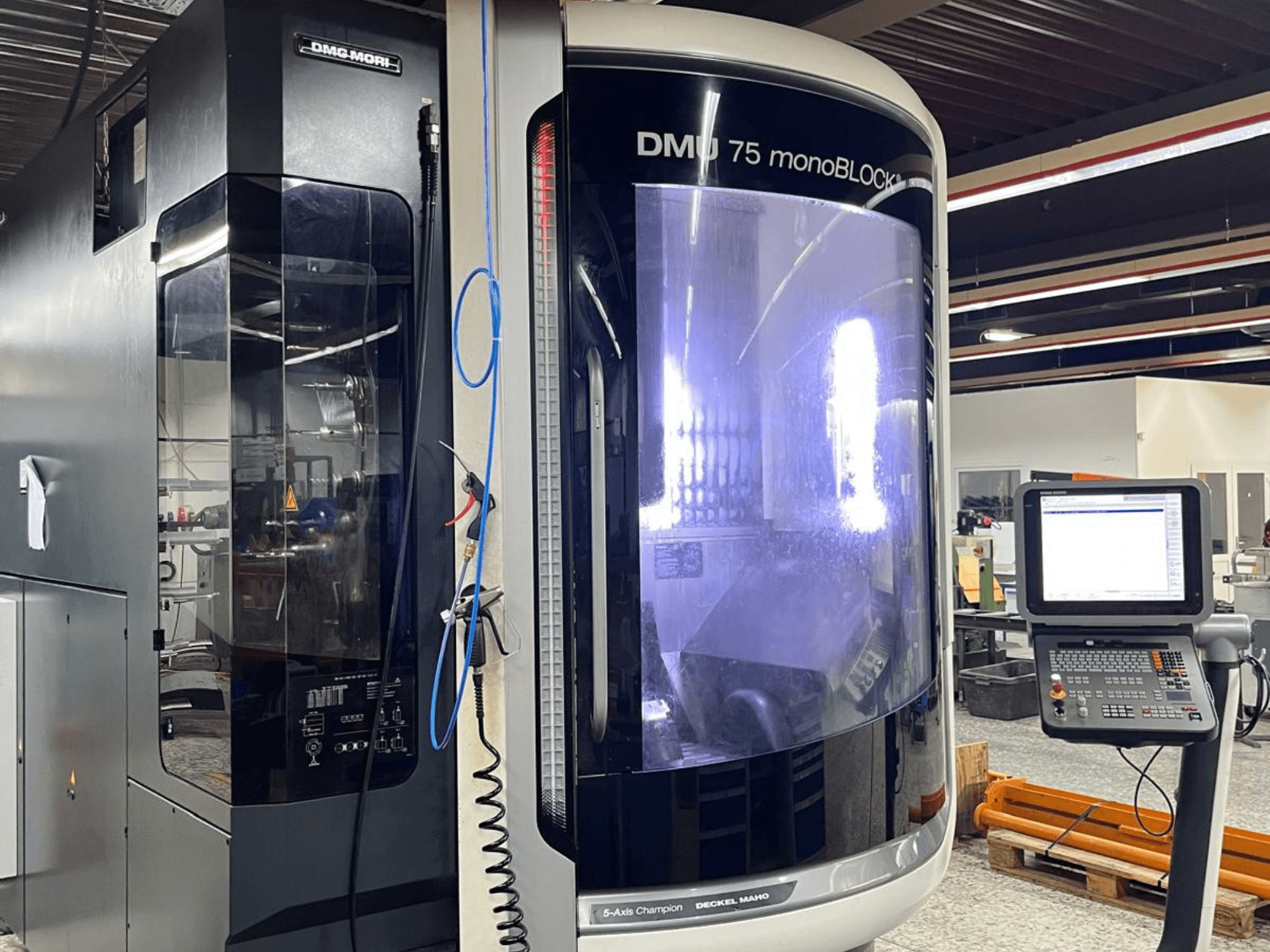 Uniwersalne centrum obróbcze DMG MORI DMU 75 MonoBlock, widok z przodu, panel sterowania i charakterystyczna obudowa.