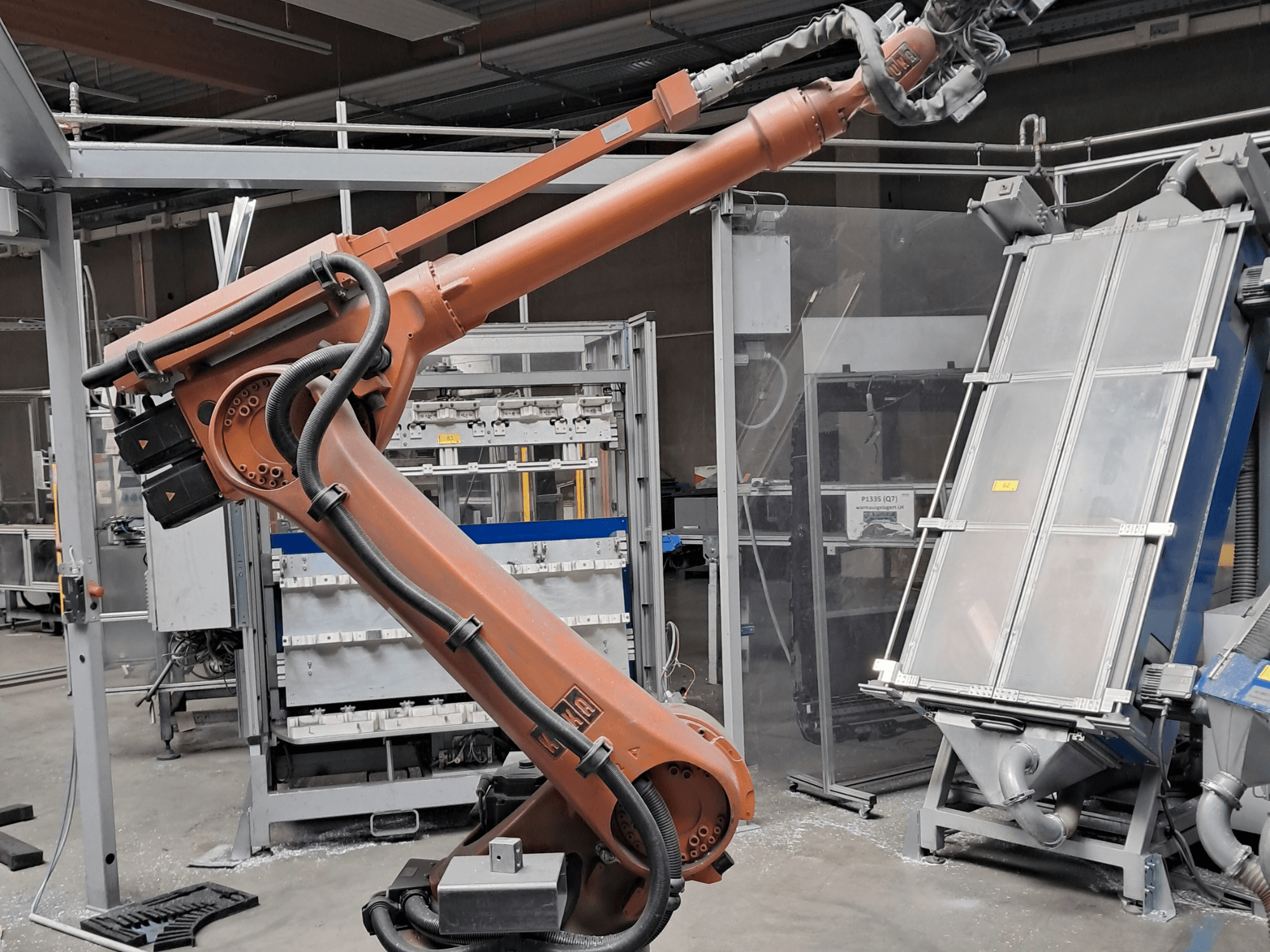Ramię robota KUKA KR 30L16-2 w warunkach fabrycznych, widok z boku przedstawiający kable i elementy mechaniczne.
