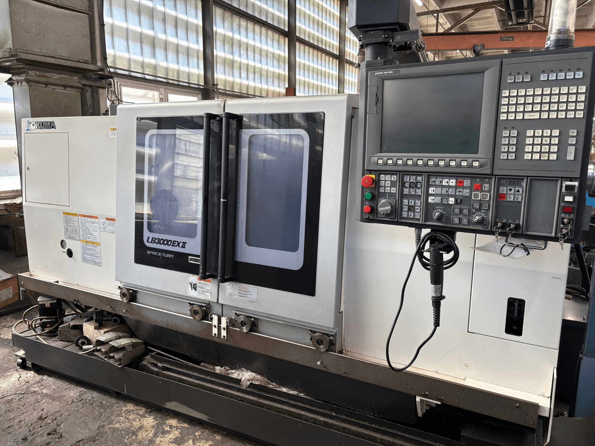 Pozioma tokarka Okuma LB3000EXII – widok z przodu przedstawiający panel sterowania i drzwiczki załadowcze.