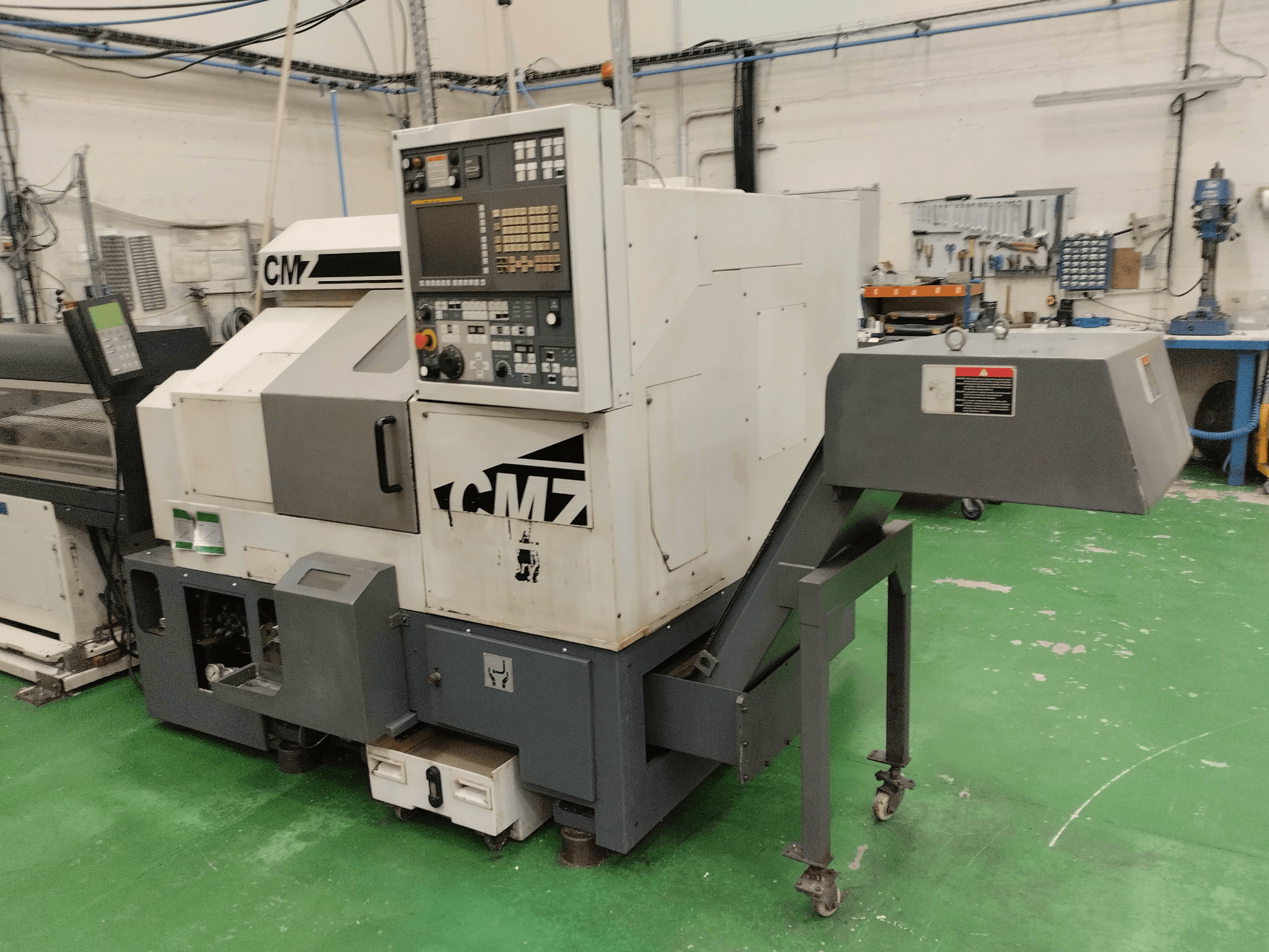 Centrum frezarskie CMZ TB-67M w widoku z przodu, z panelem sterowania i mechanizmem podającym, ustawione w środowisku warsztatowym.