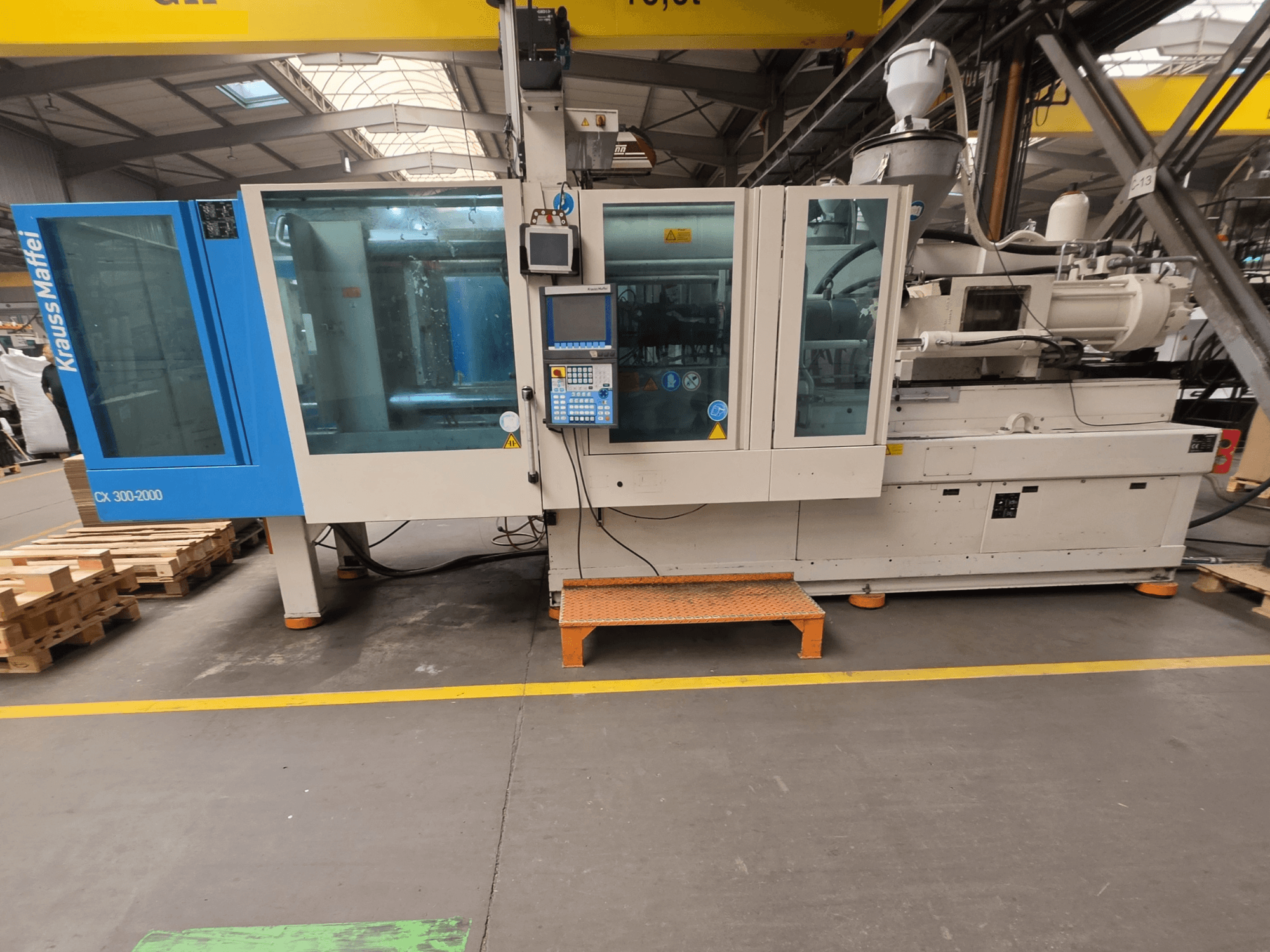 Hydrauliczna wtryskarka Krauss Maffei 300-2000 CX, widok z boku przedstawiający panel sterowania i duże okna.