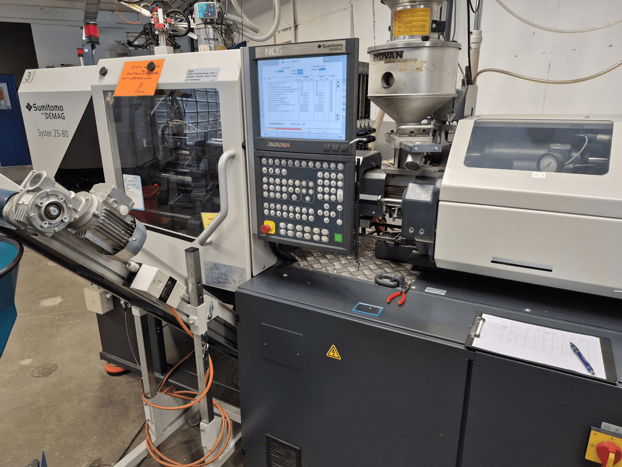 Hydrauliczna wtryskarka SUMITOMO SHI DEMAG Systec 25/320-80, widok z przodu z widocznym panelem sterowania i układem podawania materiału.