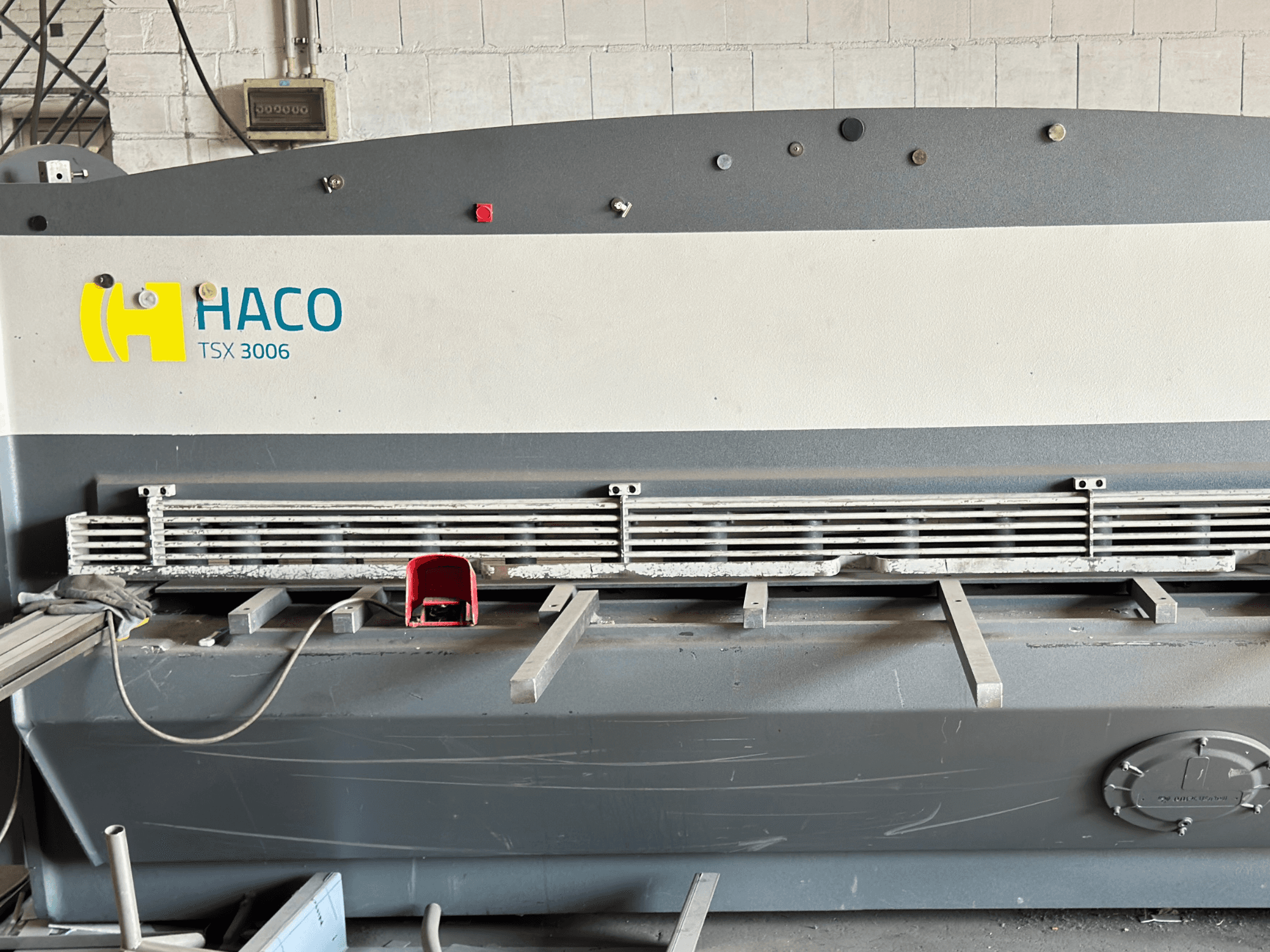 Nożyce hydrauliczne HACO TSX3006 MOT, widok z przodu, z metalowymi ostrzami tnącymi i panelem sterowania, pokazujące szczegóły operacyjne.