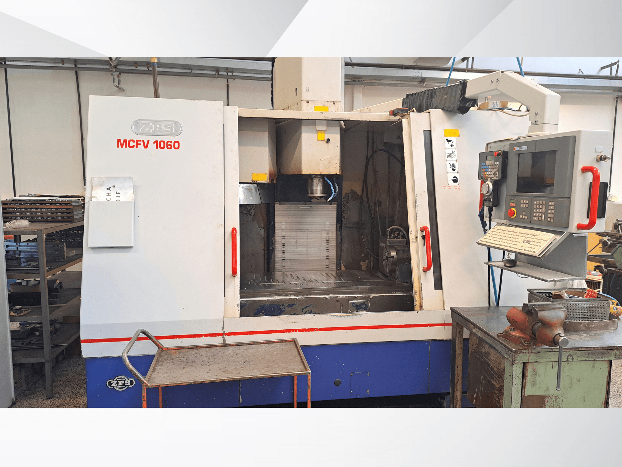 Maszyna CNC ZPS MCFV 1060 w warsztacie, widok z przodu przedstawiający panel sterowania, wrzeciono i obszar roboczy; kolory metaliczny szary i niebieski.