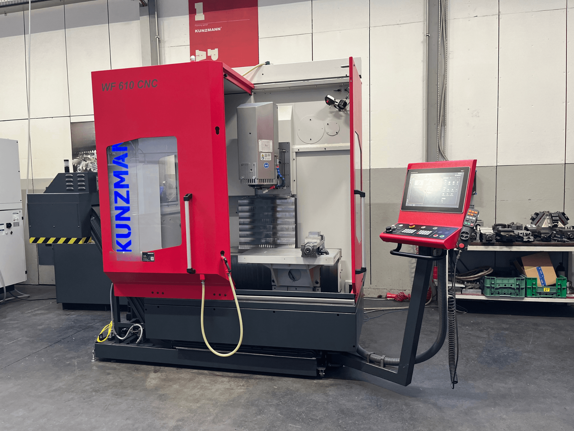 Pionowe centrum obróbcze KUNZMANN WF 610 CNC w warsztacie, z panelem sterowania i widocznymi elementami maszyny.