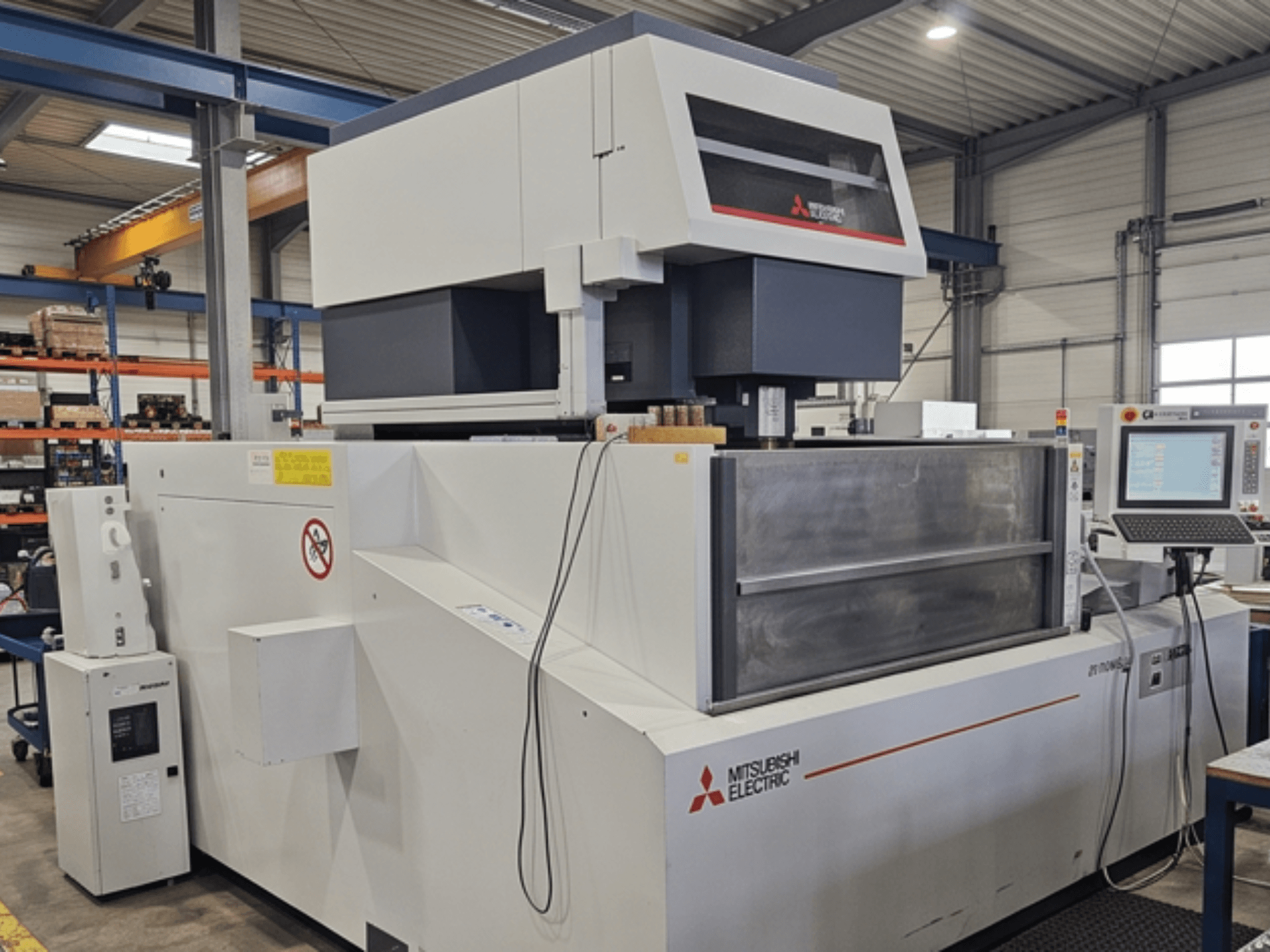 Maszyna do elektroerozji drutowej Mitsubishi MV-4800, widok z przodu, przedstawiająca panel sterowania i obszar roboczy w warunkach fabrycznych.