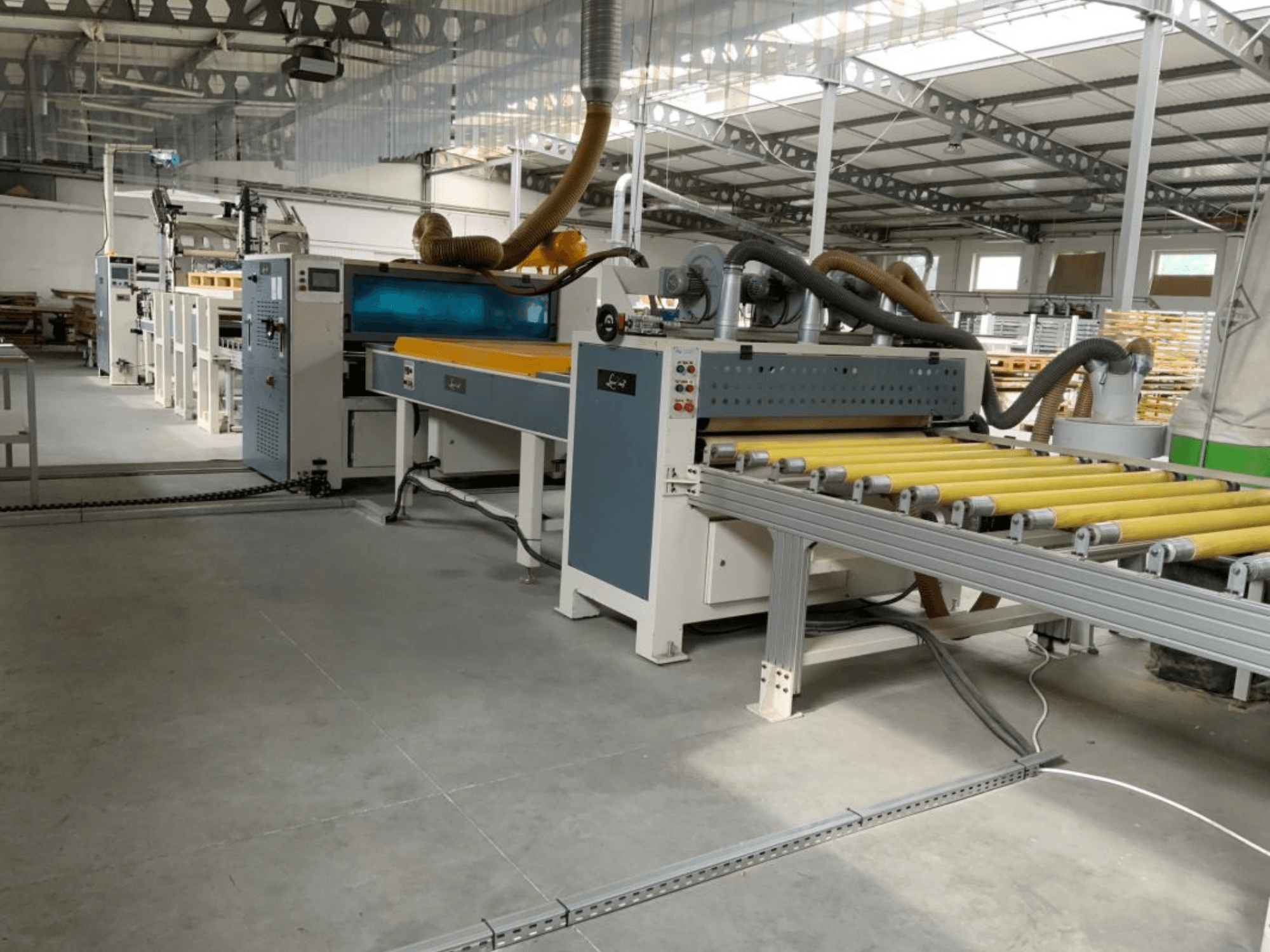 Prasa do laminowania MASTER PUR-1400 w warunkach fabrycznych, widok z przodu, z widocznymi rolkami i elementami sterującymi.