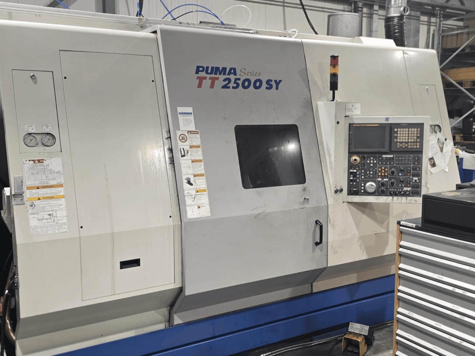 Tokarka CNC PUMA serii TT 2500 SY, widok z przodu; panel sterowania z widocznymi pokrętłami i przyciskami, wskaźnikami i etykietami obsługi.