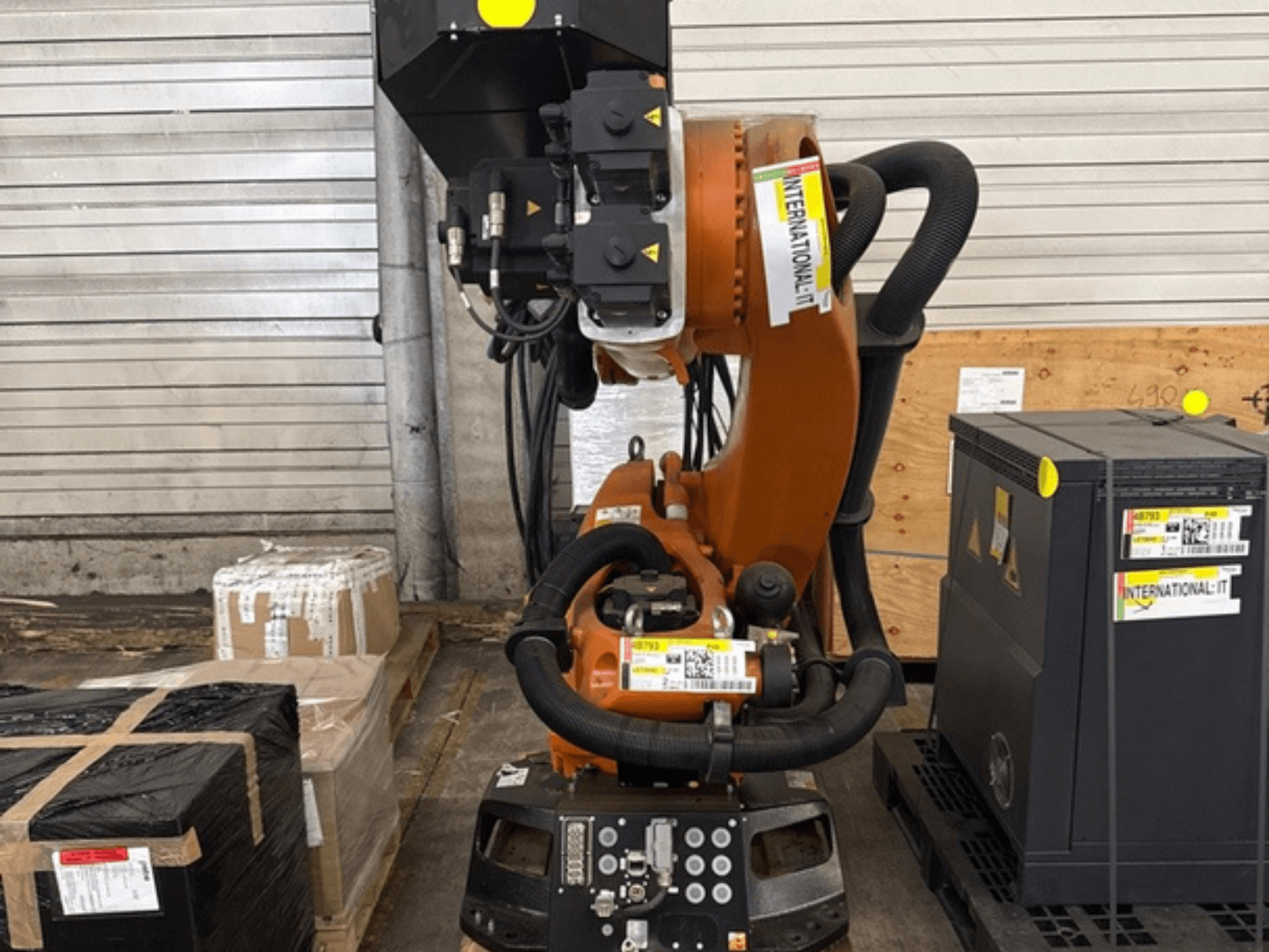 Dodatkowe ramię robota KUKA KR 210 R2700 widziane z przodu, umieszczone na palecie obok opakowań i sprzętu.