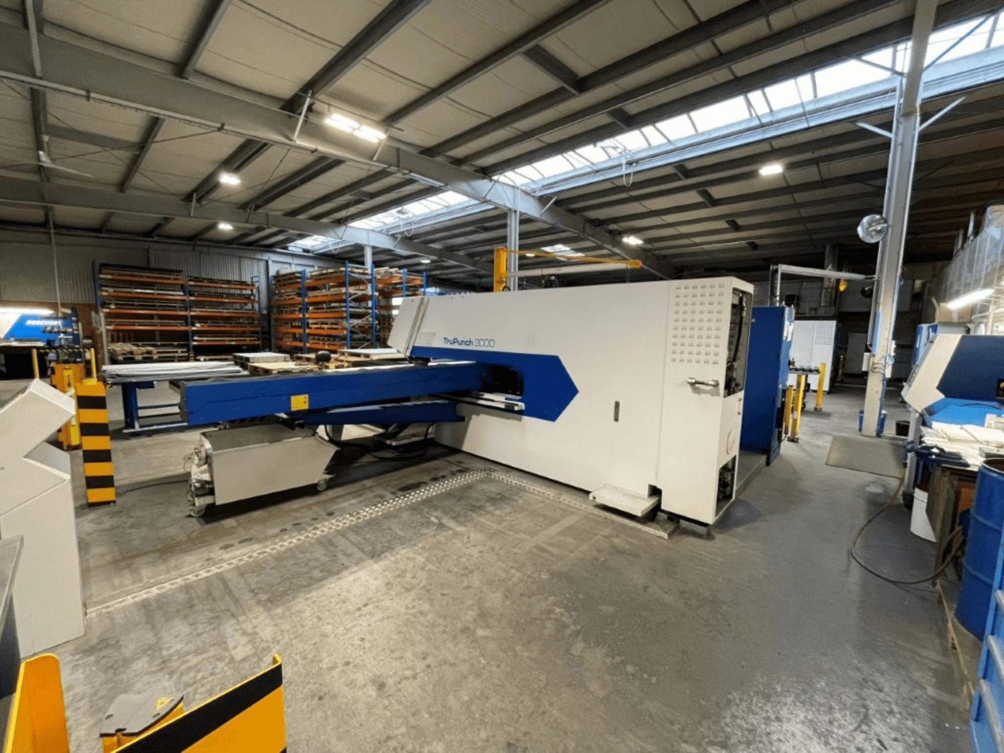 Prasa wykrawająca CNC TRUMPF TruPunch 3000 w środowisku fabrycznym – widok z przodu pozwala dostrzec jej niebiesko-białą kolorystykę oraz elementy robocze.