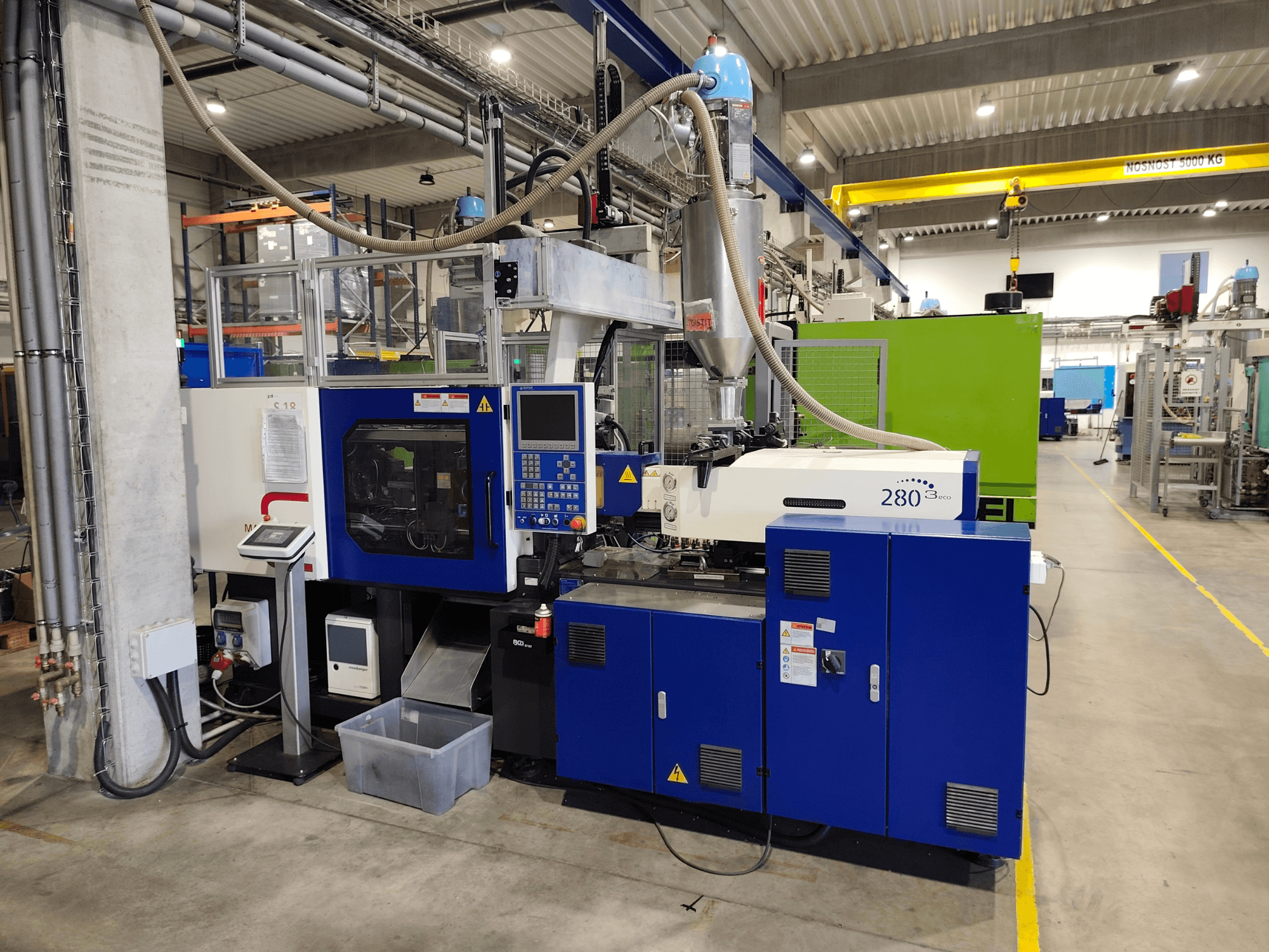 Hydrauliczna wtryskarka HAITIAN Mars III MA 900/280 A ECO, widok z boku, przedstawiający elementy sterujące i zespół podający.