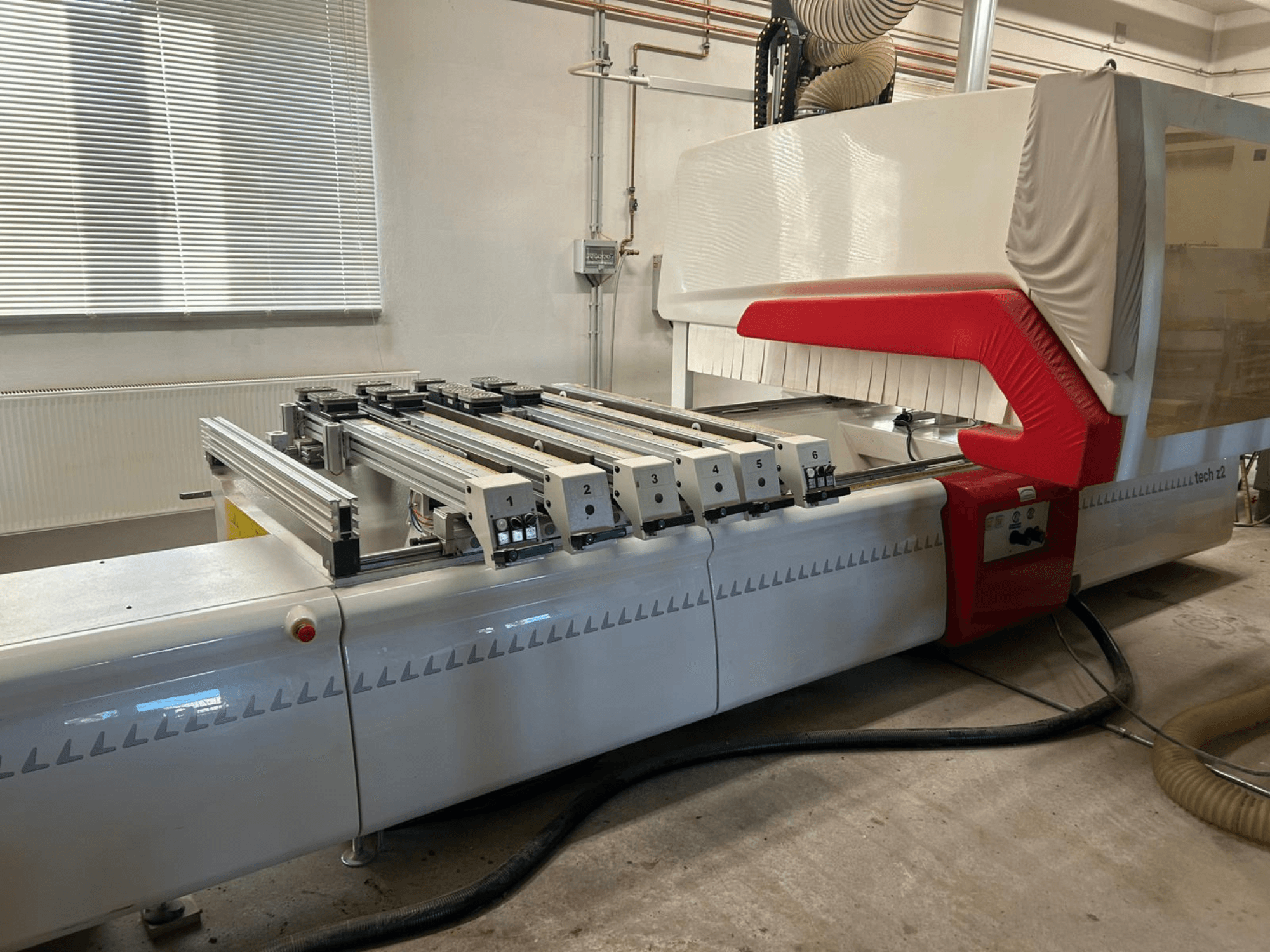 Wytaczarka do drewna SCM TECH Z2-27-C, widok z boku, pokazujący panel sterowania i szyny, z czerwono-białymi elementami konstrukcyjnymi.