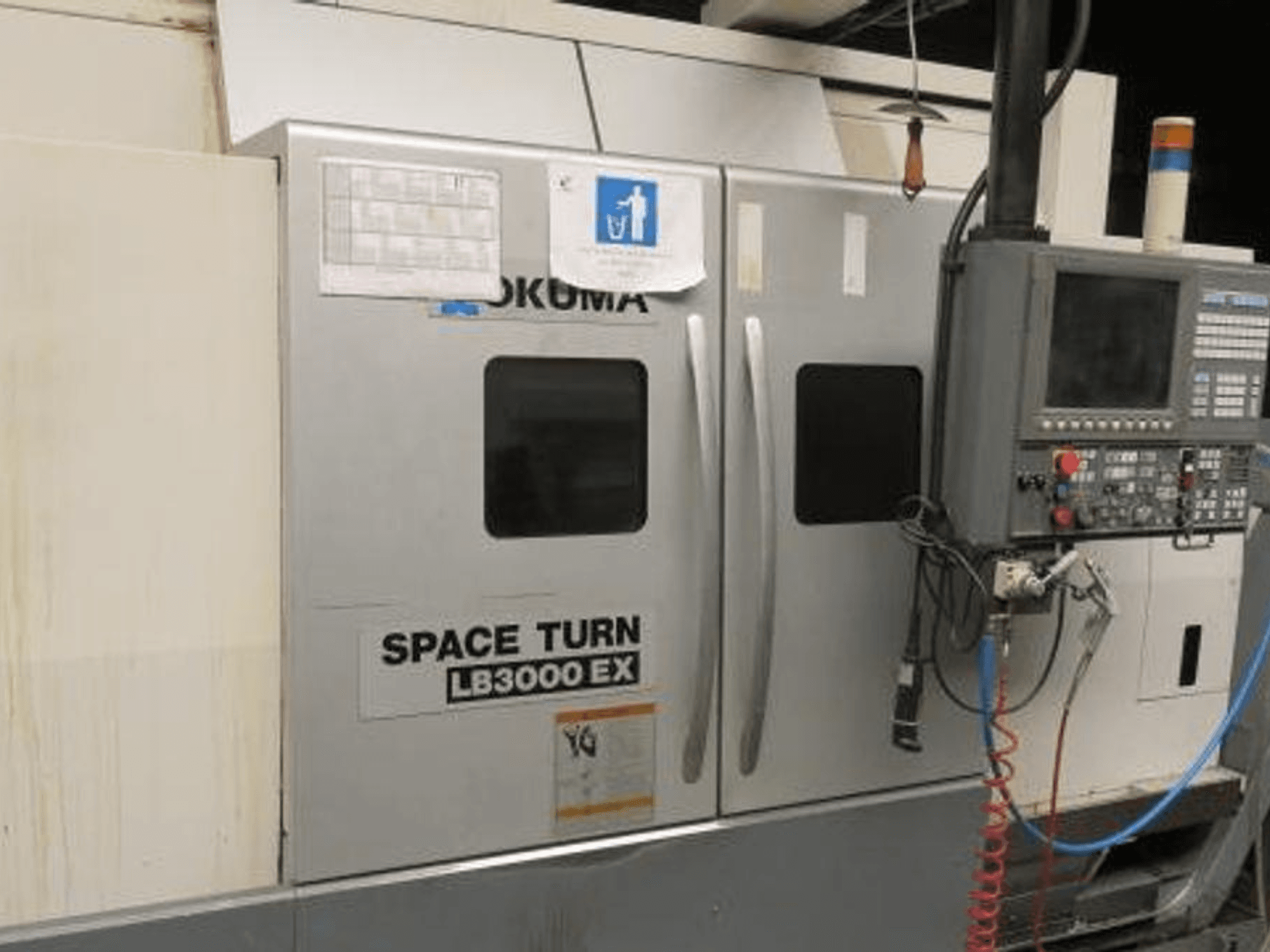 Tokarka CNC Okuma Space Turn LB3000 EX, widok z boku, z panelem sterowania, dwojgiem drzwi i widocznym okablowaniem.